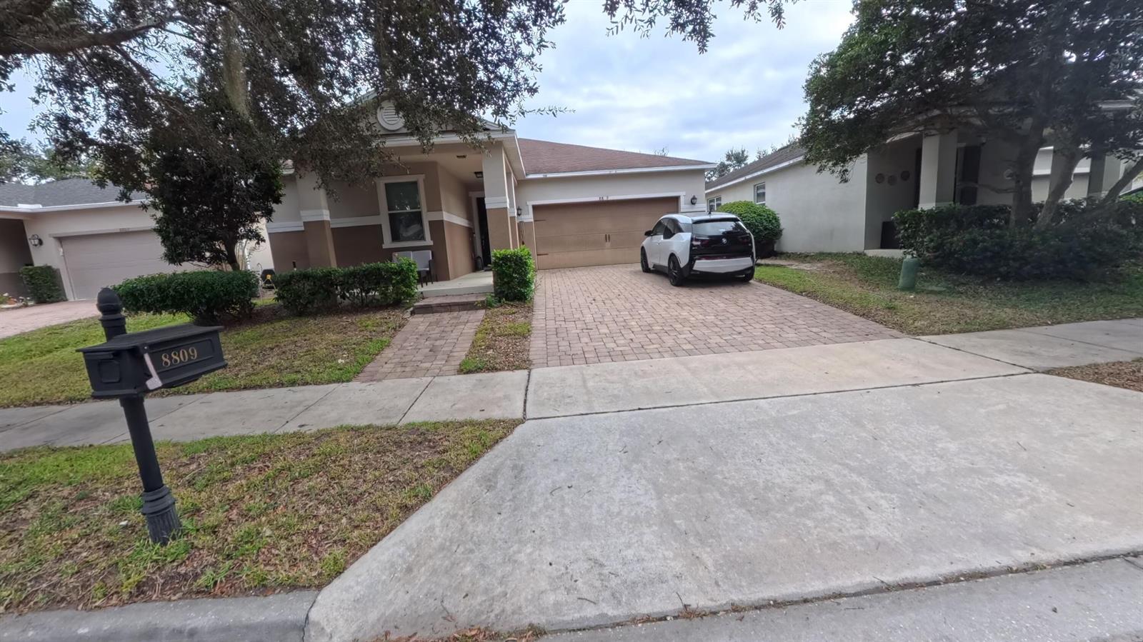 A tan single-story house with a paved driveway, a two-car garage, and a black mailbox — 8809 Arrabida Lane, Orlando FL 32836, ORLANDO, FL