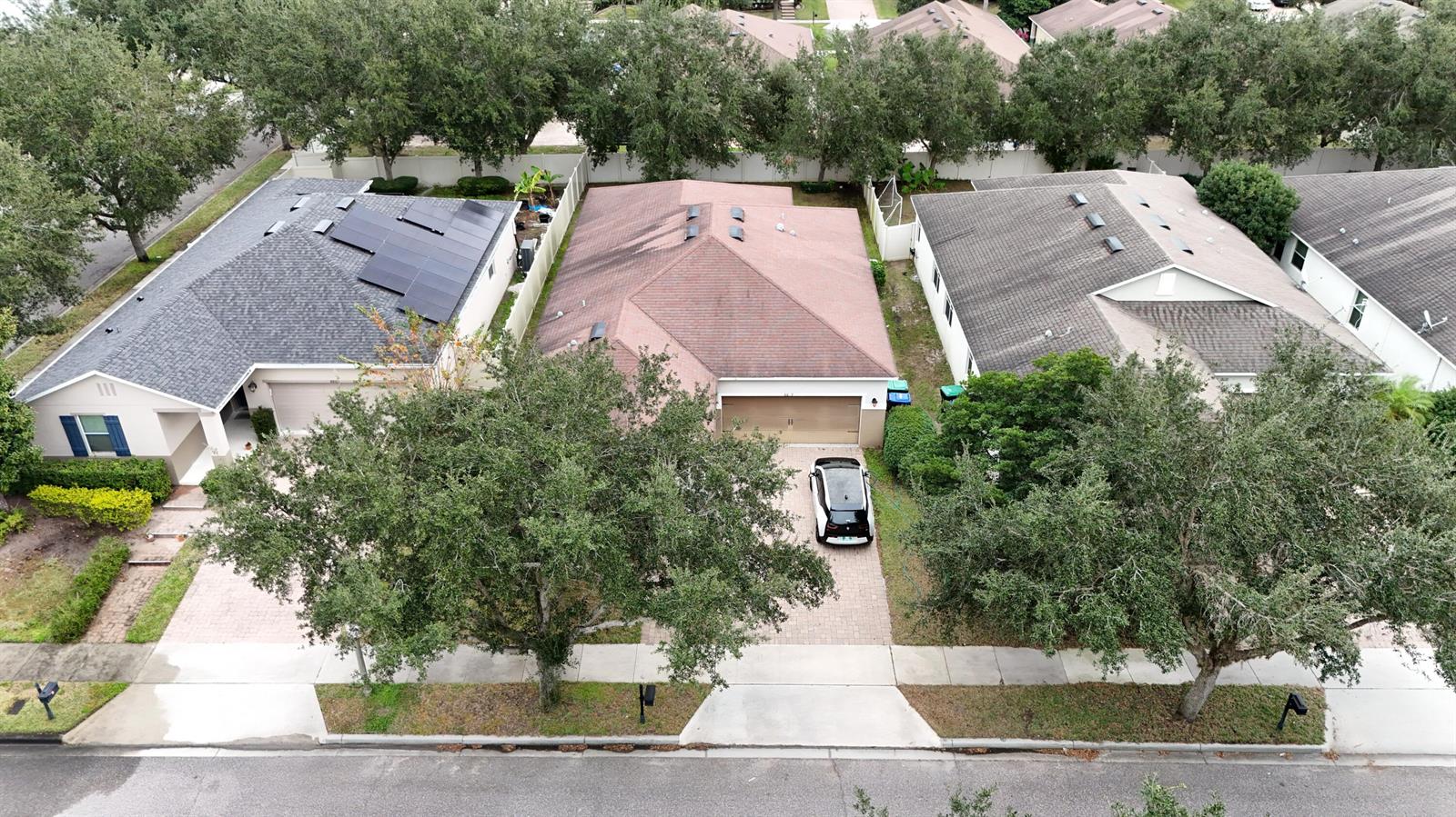 An aerial view shows three suburban houses with driveways and trees along a paved street — 8809 Arrabida Lane, Orlando FL 32836, ORLANDO, FL
