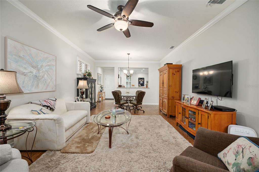 A living room features a white sofa, a television, a dining area, and a ceiling fan — 9497 SW 76TH STREET, OCALA, FL
