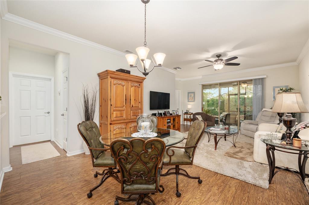 A dining area with a glass table and chairs opens into a living room — 9497 SW 76TH STREET, OCALA, FL