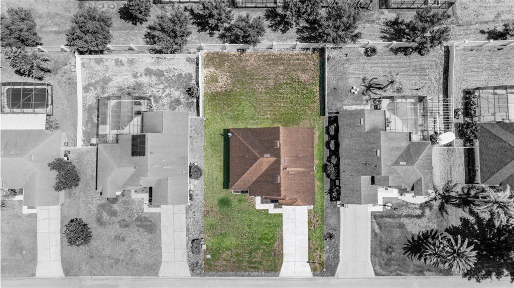 An aerial view shows a single-family house with a brown roof and a large backyard — 437 VIA DEL SOL DRIVE, DAVENPORT, FL