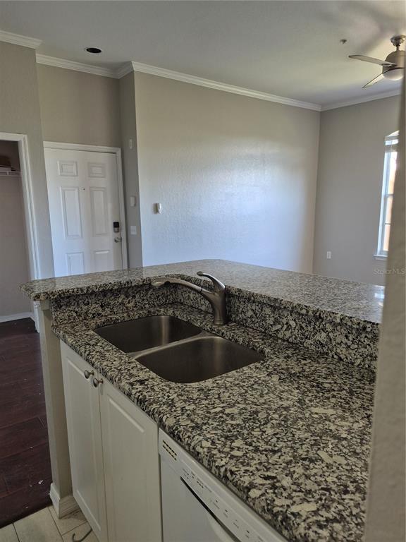 A kitchen sink with a granite countertop and white cabinets in an open-concept room — 5146 NORTHRIDGE ROAD UNIT 309, SARASOTA, FL