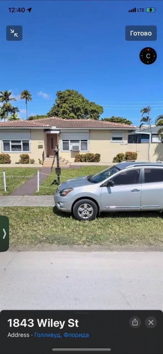 A single-story house with a tan exterior, a tiled roof, and a silver car parked outside — 1843 Wiley St, Hollywood FL 33020, HOLLYWOOD, FL