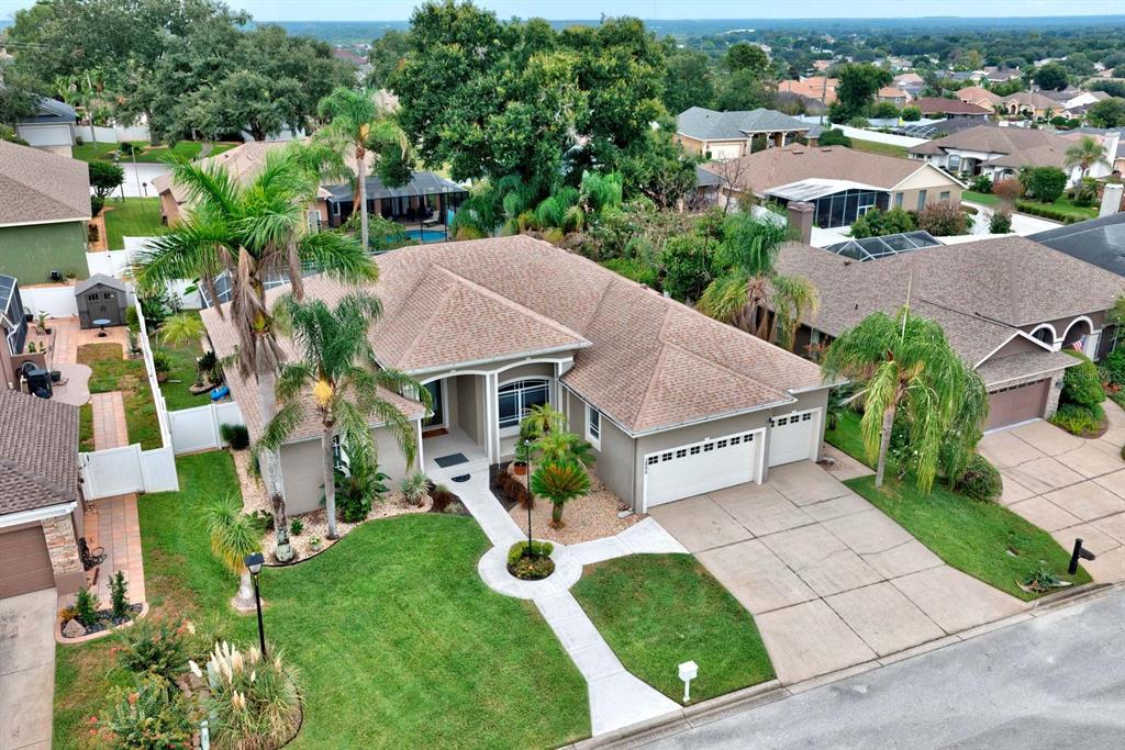 An aerial view shows a single-story suburban house with a tan roof and driveway — 2856 MERIDIAN POINT LANE, LAKELAND, FL