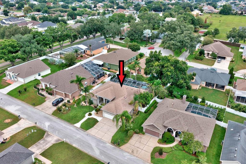 An aerial view shows a suburban house with a brown shingled roof and screened pool — 2856 MERIDIAN POINT LANE, LAKELAND, FL