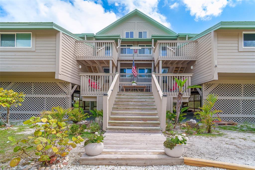 A two-story house with light brown siding, a central staircase, and lattice-enclosed ground level — 9200 LITTLE GASPARILLA ISLAND UNIT 403, PLACIDA, FL