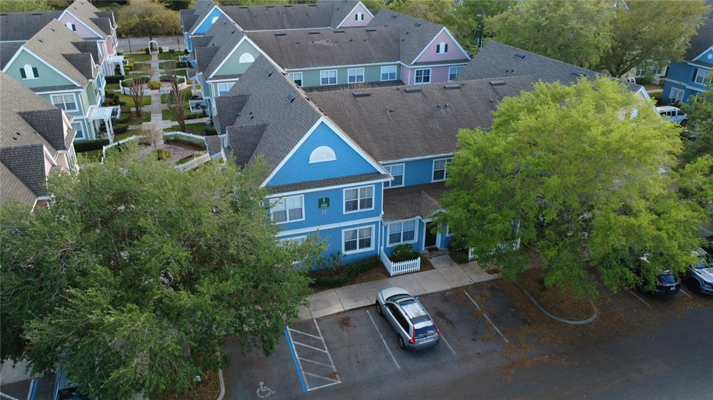 An aerial view shows a blue multi-story residential building with a parking lot — 4000 SAN GALLO DRIVE UNIT 105, KISSIMMEE, FL
