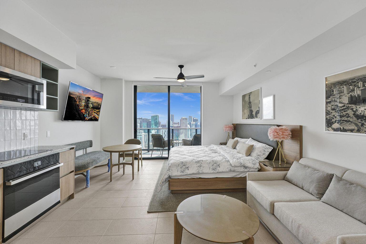 A studio apartment featuring a kitchen, bed, sofa, and a balcony with city views — 601 NE 1st Avenue # 4712, Miami FL 33132, MIAMI, FL