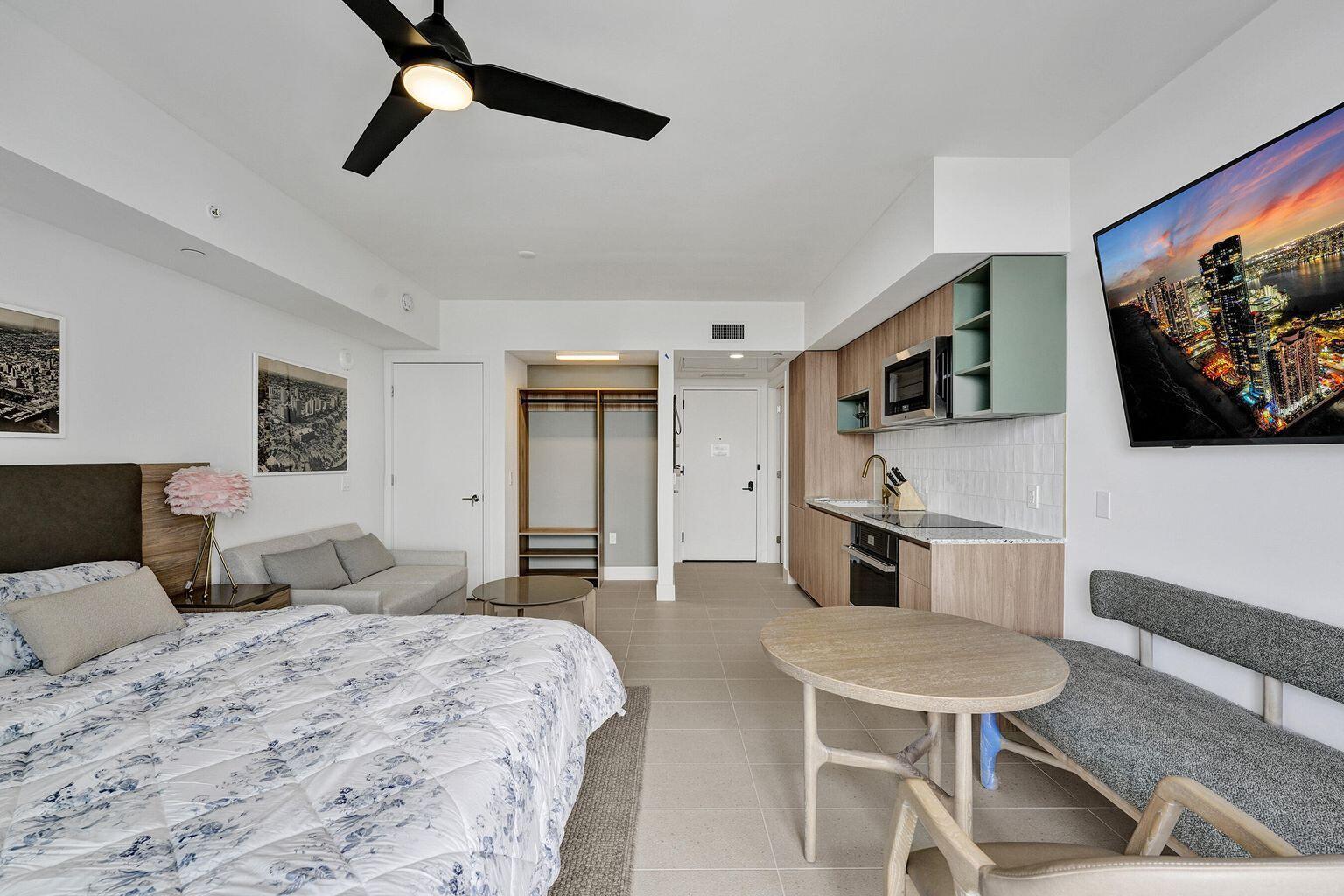 A studio apartment featuring a bed, kitchenette, dining area, and a wall-mounted television — 601 NE 1st Avenue # 4712, Miami FL 33132, MIAMI, FL