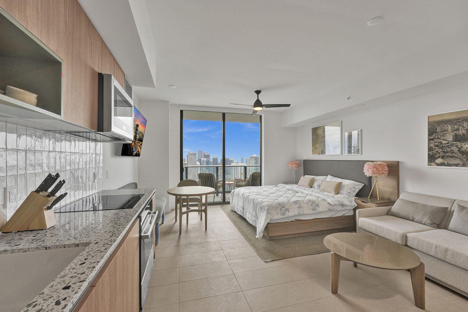 A studio apartment features a kitchen, bed, seating area, and a balcony with city views — 601 NE 1st Avenue # 4712, Miami FL 33132, MIAMI, FL