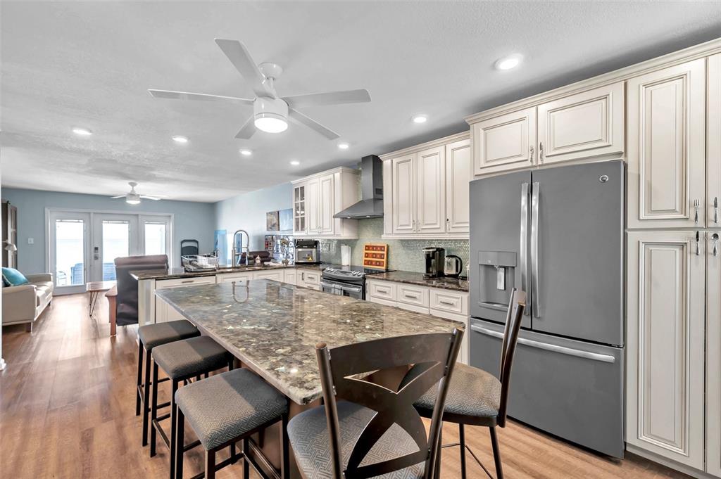 A kitchen with a large granite island, stainless steel appliances, and cream-colored cabinetry — 4768 COQUINA KEY DRIVE SE, ST PETERSBURG, FL