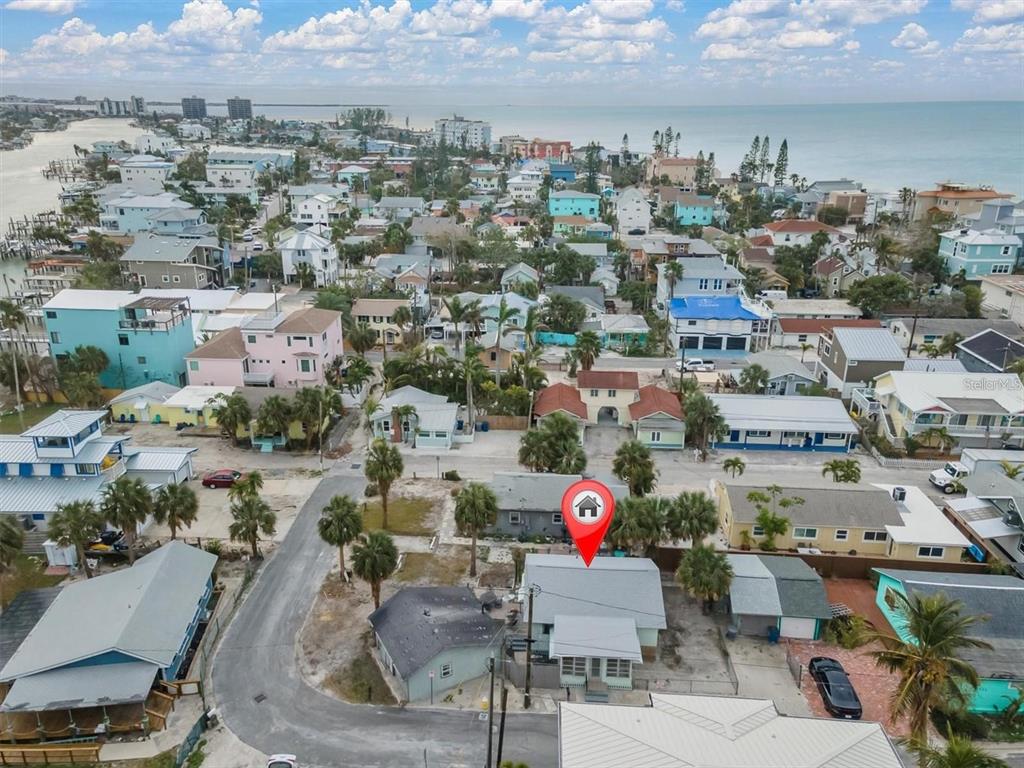 An aerial view shows a coastal neighborhood with a marked house in the foreground — 137 91ST AVENUE, TREASURE ISLAND, FL