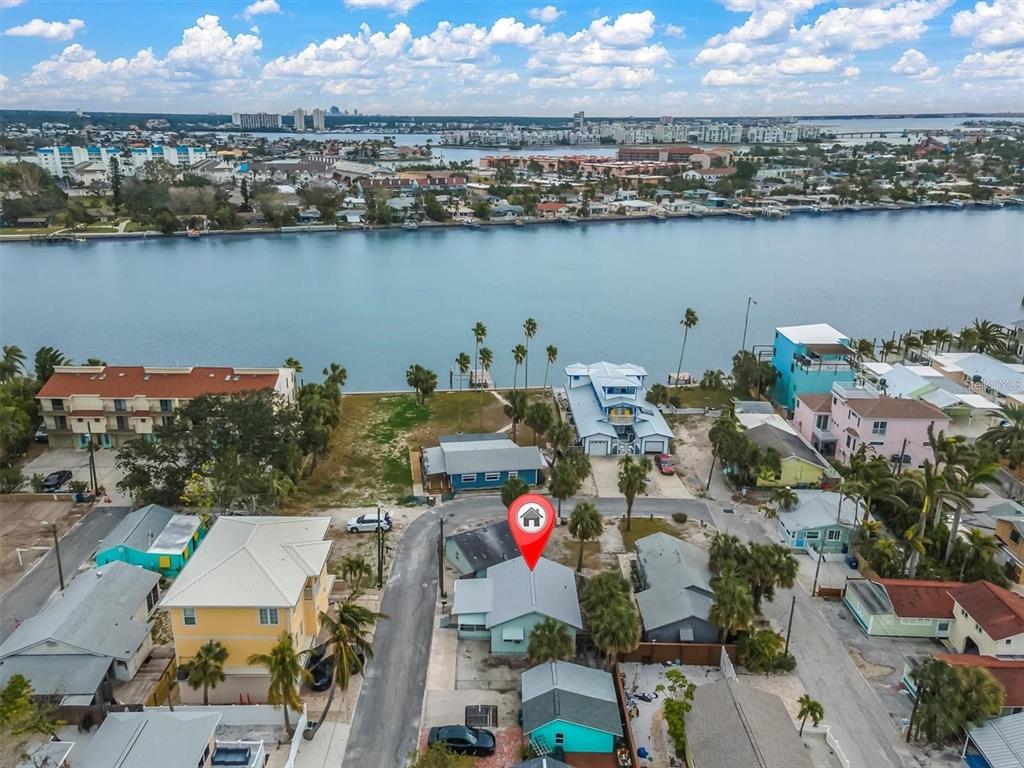 An aerial view shows a residential neighborhood with a marked house near the waterfront — 137 91ST AVENUE, TREASURE ISLAND, FL