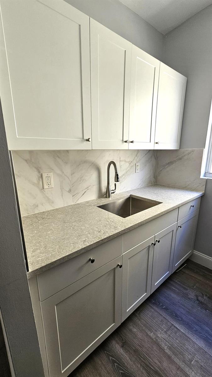 A kitchen with white cabinets, stainless steel appliances, and wood-look flooring in an open room — 1142 SW 4th Street # 9, Miami FL 33130, MIAMI, FL