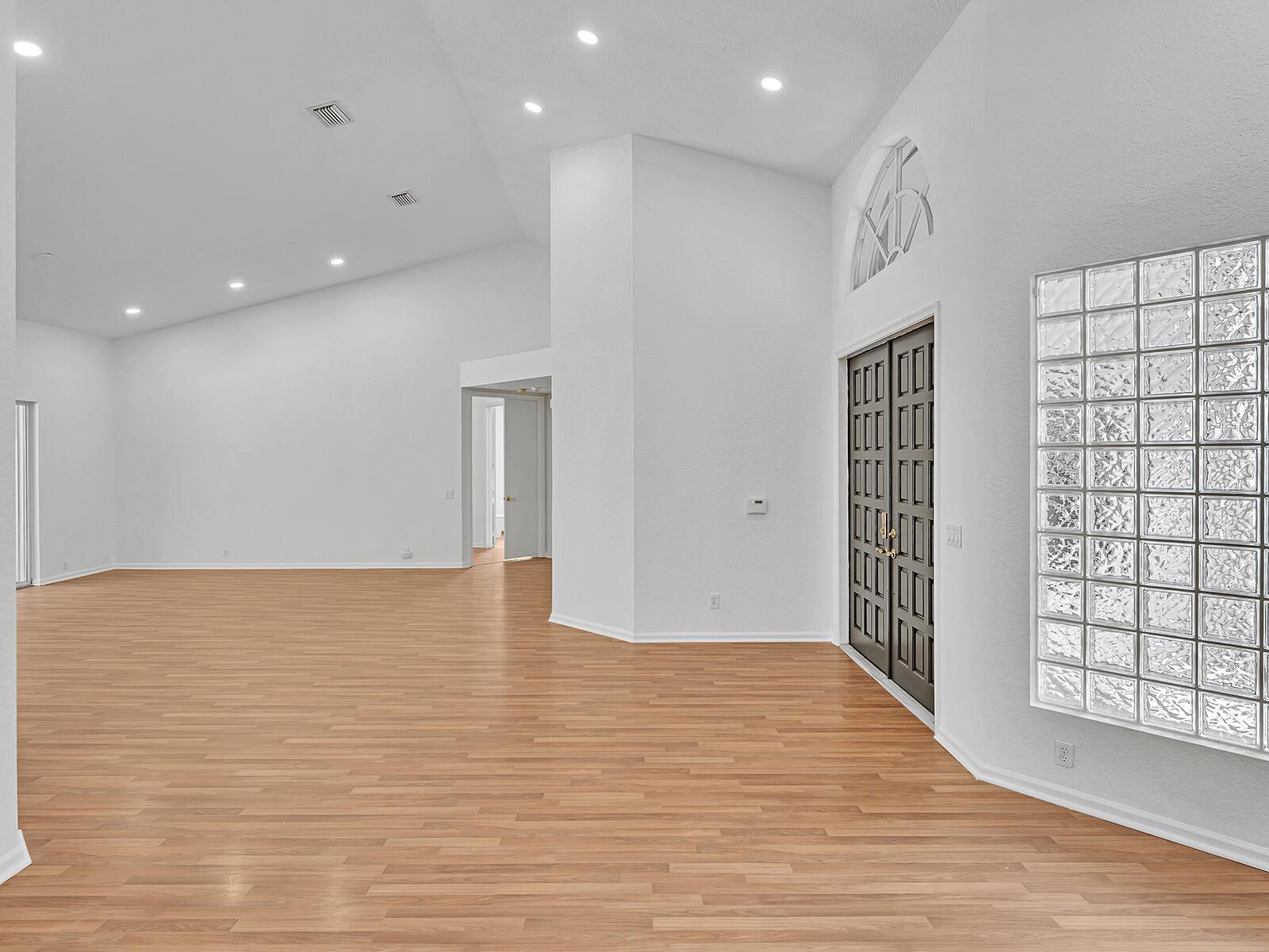 An empty room with light wood flooring, white walls, recessed lighting, and a glass block window — 3420 Washington Lane, Cooper City FL 33026, COOPER CITY, FL