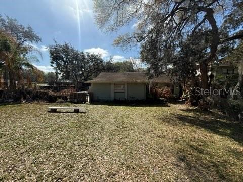 A view of the back of a single-story house with a large yard — 684 STRATFORD DRIVE, DELAND, FL