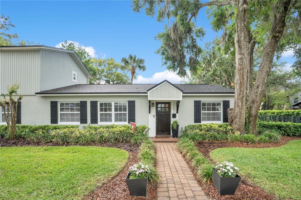 A single-story house with a brick walkway, dark shutters, and a dark wood front door — 2702 PARKLAND DRIVE, WINTER PARK, FL