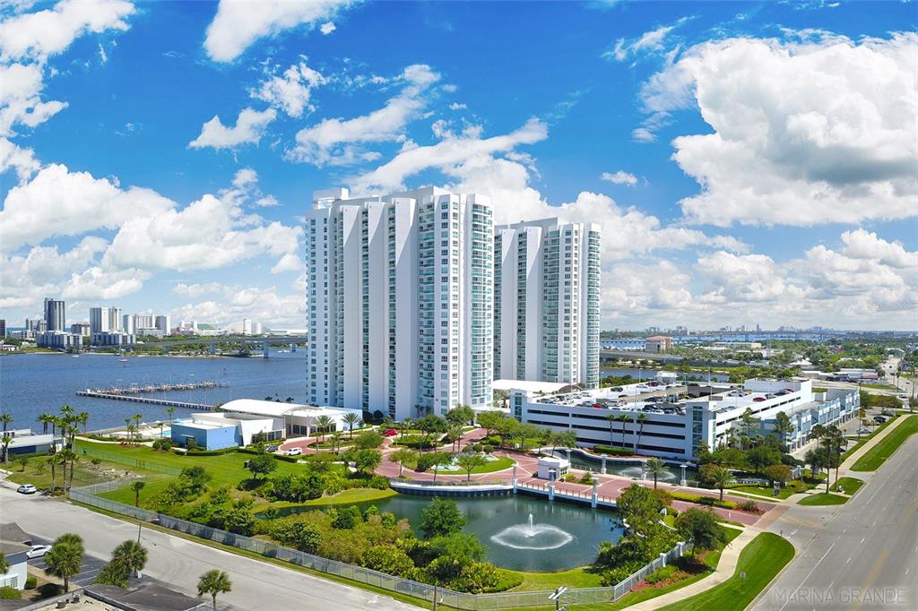 An aerial view of a tall white residential building complex with a fountain and parking — 235 RIVERSIDE DRIVE, DAYTONA BEACH, FL