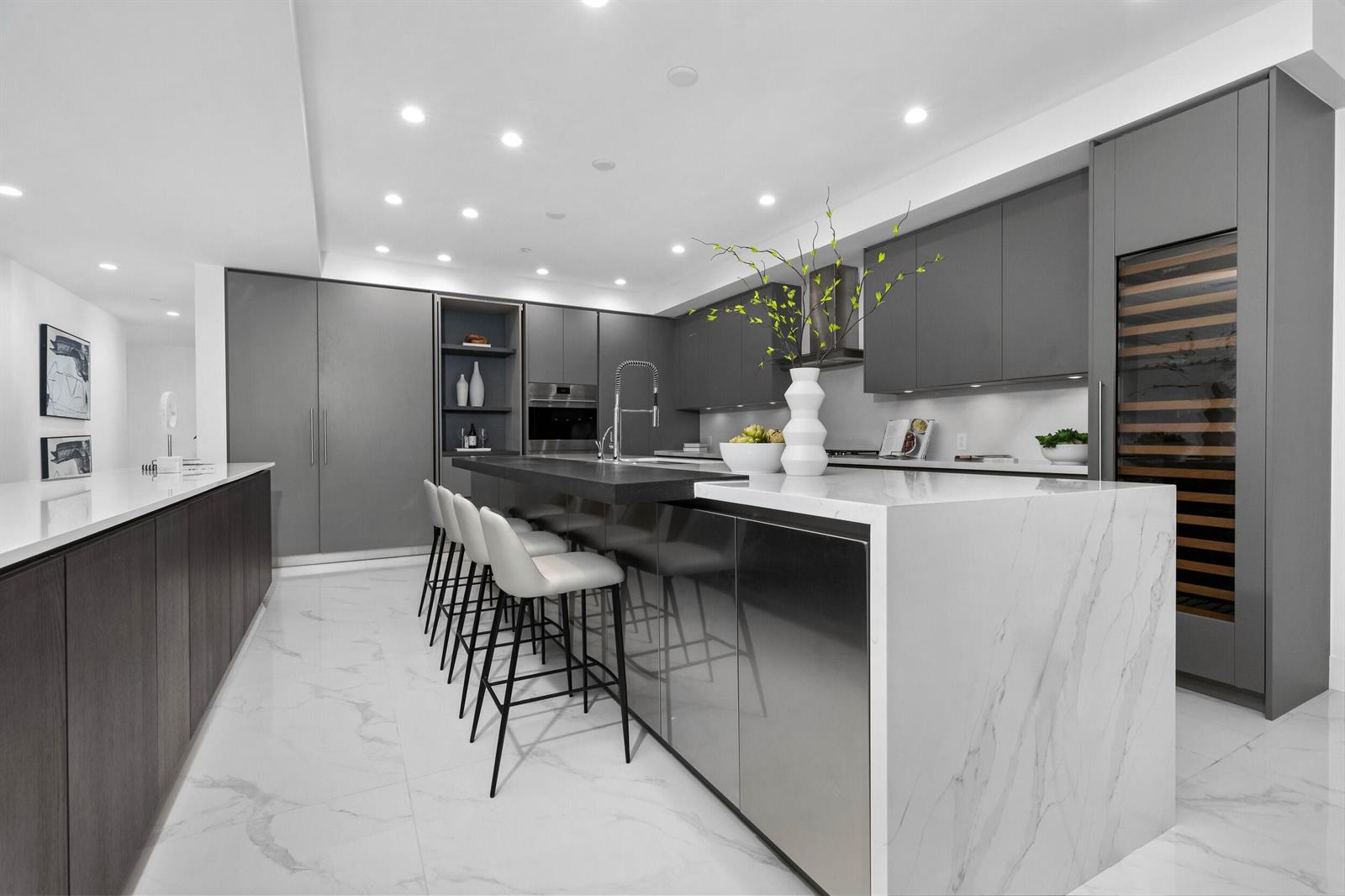 A modern kitchen features a marble waterfall island, gray cabinetry, and white tile flooring — 495 E Royal Palm Road # 201, Boca Raton FL 33432, BOCA RATON, FL