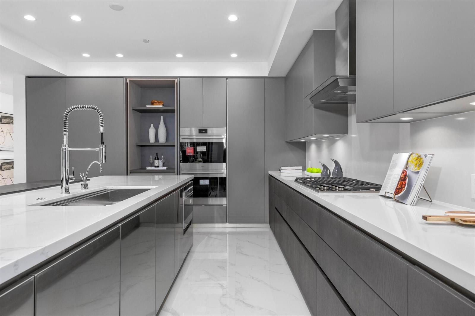 A modern kitchen features gray flat-panel cabinetry, white marble countertops, and a large center island — 495 E Royal Palm Road # 201, Boca Raton FL 33432, BOCA RATON, FL