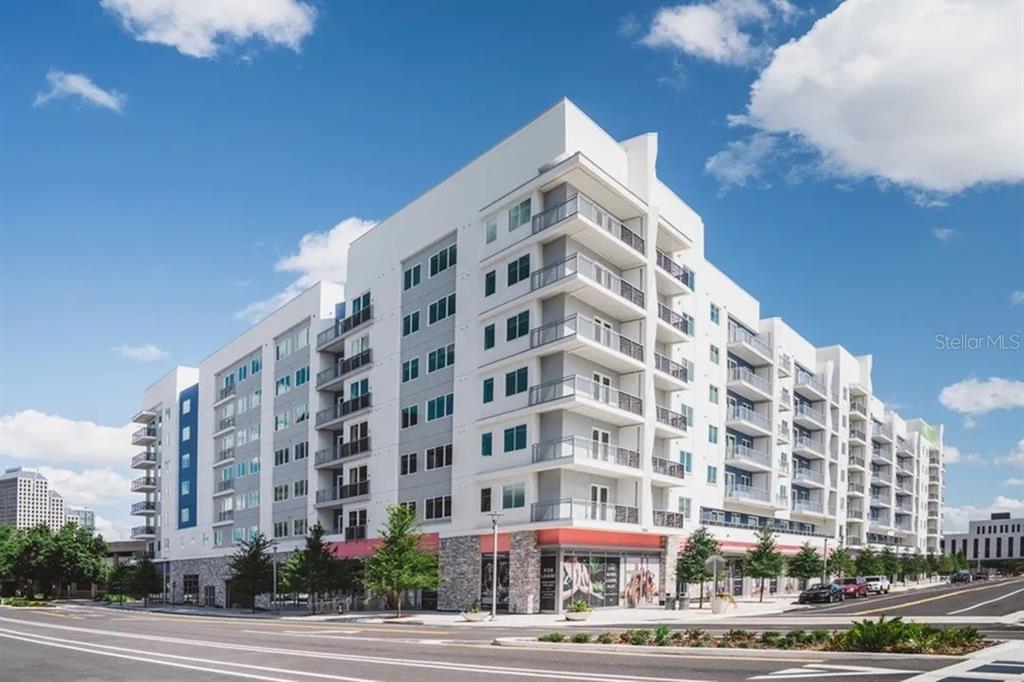 A modern multi-story apartment building with balconies and ground-floor retail space sits on a corner — 505-3 CHATHAM AVE AVENUE, ORLANDO, FL