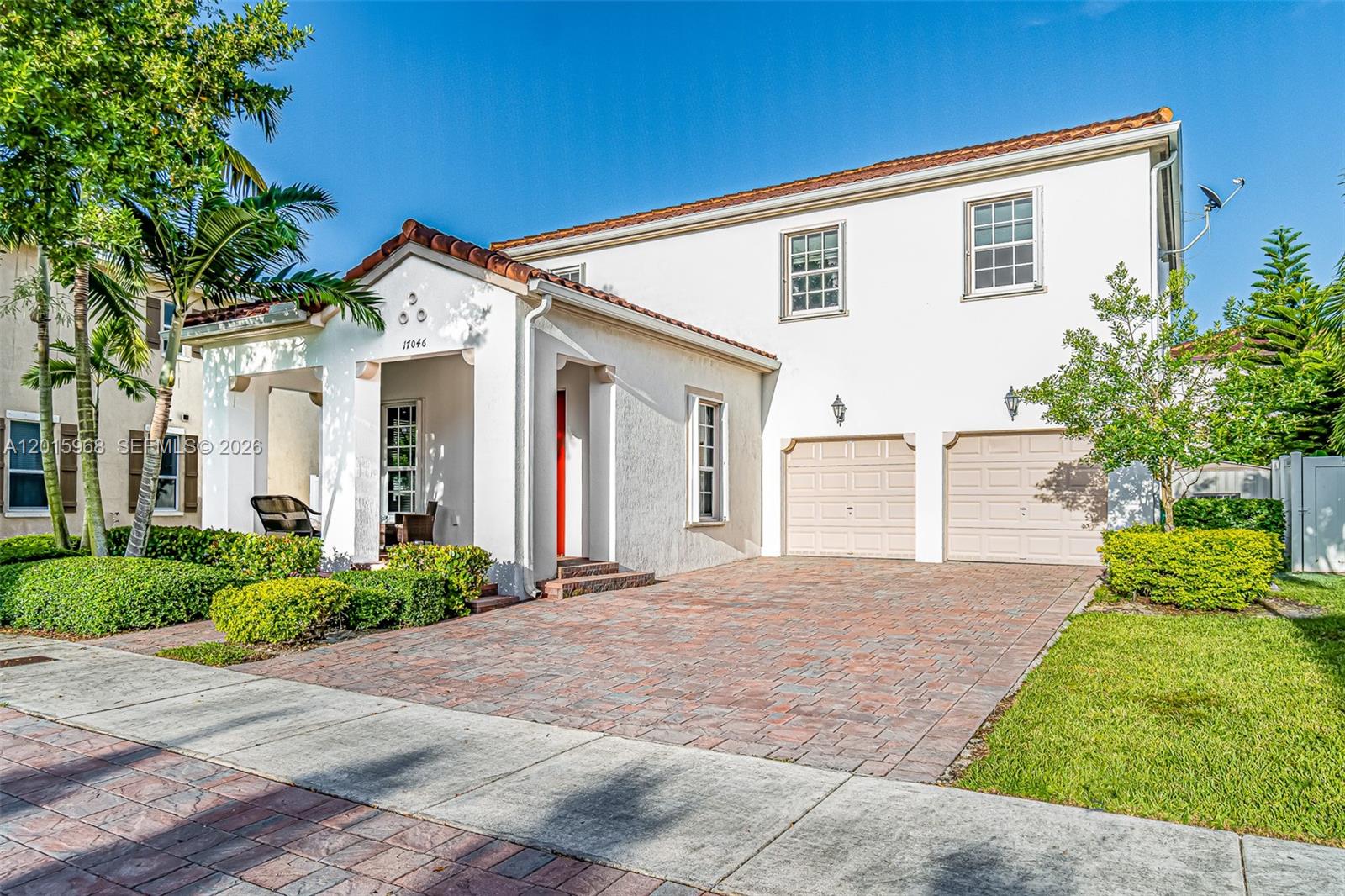 A two-story white stucco house features a red tile roof and a brick paver driveway — 17046 SW 94th Ln, Miami FL 33196, MIAMI, FL