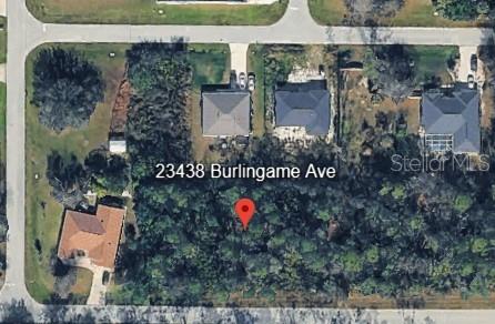 This aerial map shows a vacant, wooded residential lot situated between two existing houses — 23430 BURLINGAME AVENUE, PUNTA GORDA, FL