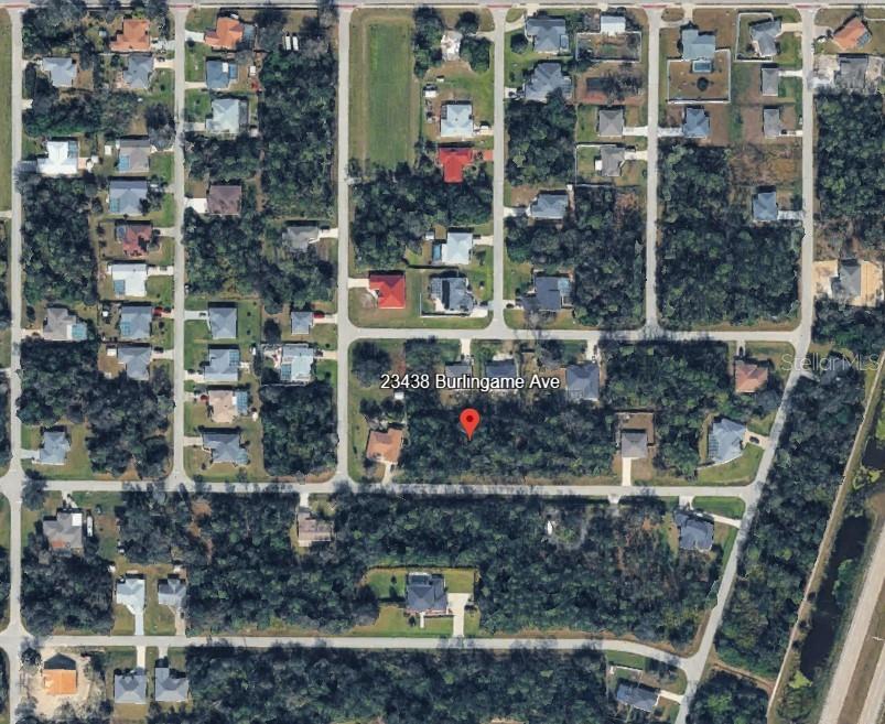 This aerial map shows a vacant, wooded residential lot surrounded by suburban houses — 23430 BURLINGAME AVENUE, PUNTA GORDA, FL