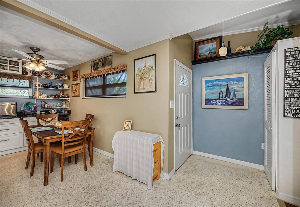 A dining area features a wooden table, chairs, open shelving, and a blue accent wall — 3017 CHICORY TERRACE, PUNTA GORDA, FL