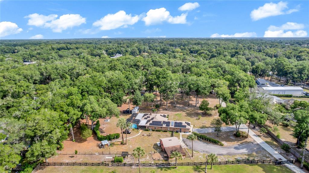 An aerial view shows a house with solar panels, a pool, and a detached building — 721 MCGREGOR ROAD, DELAND, FL