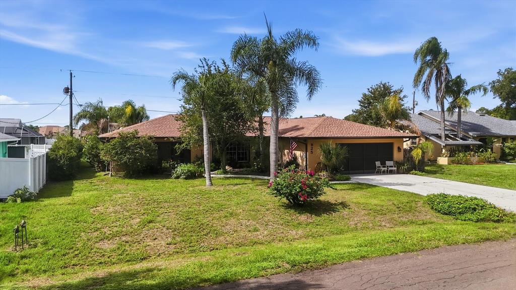 A single-story house with a brown roof, palm trees, and a front lawn — 925 N BOUNDARY ROAD, ENGLEWOOD, FL