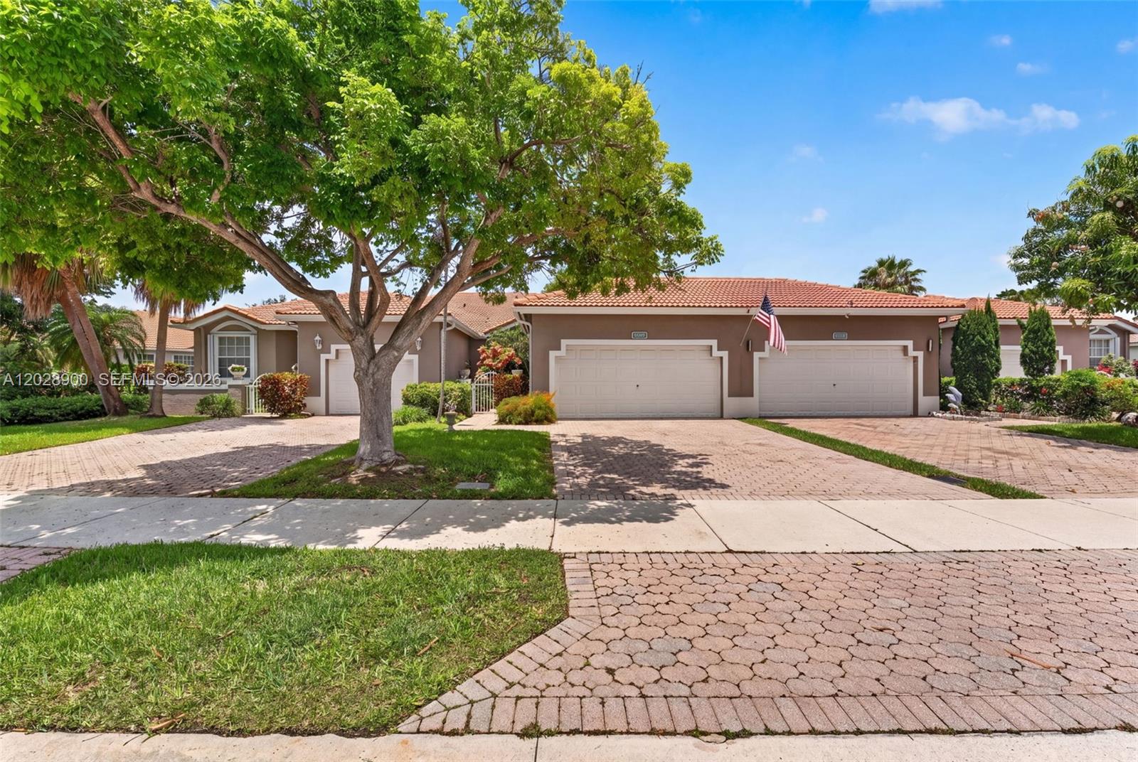 A single-story house with a terracotta tile roof, two garage doors, and a brick driveway — 2411 Aragon Blvd # 2, Sunrise FL 33322, SUNRISE, FL