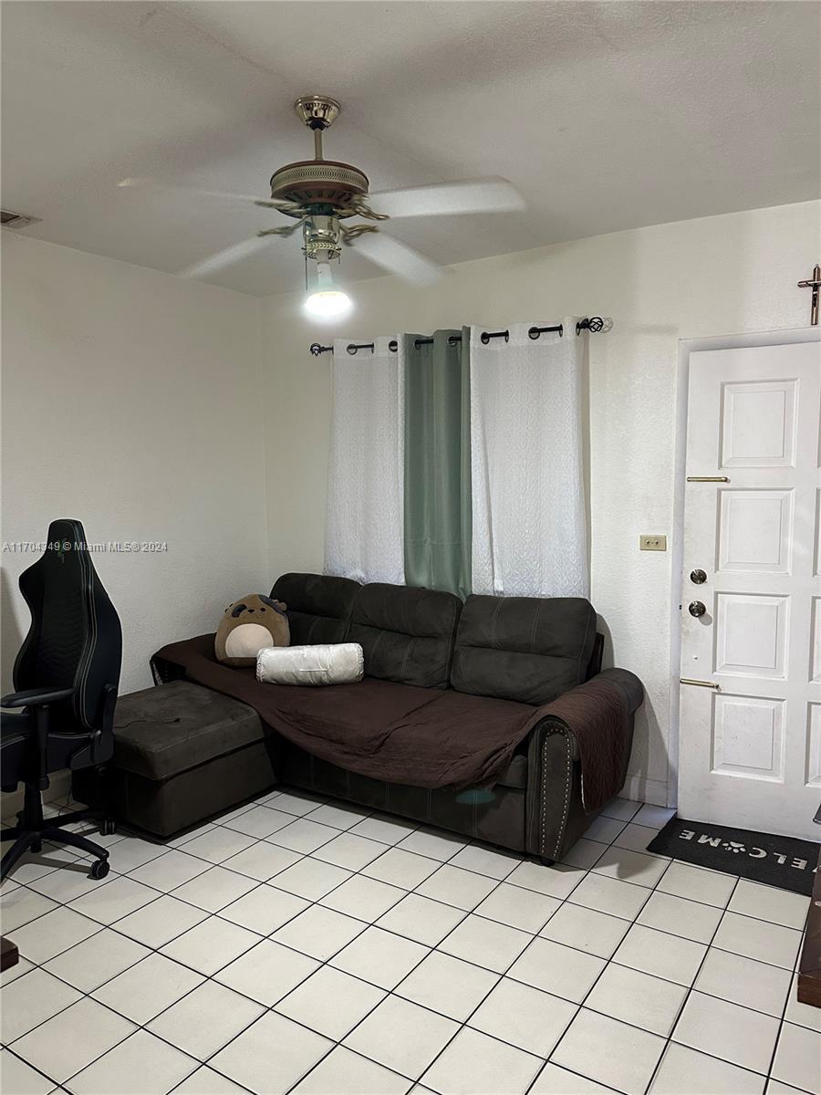 A room with white tiled floors, a brown sectional sofa, and a ceiling fan — 1838 NW 18th St, Miami FL 33125, MIAMI, FL