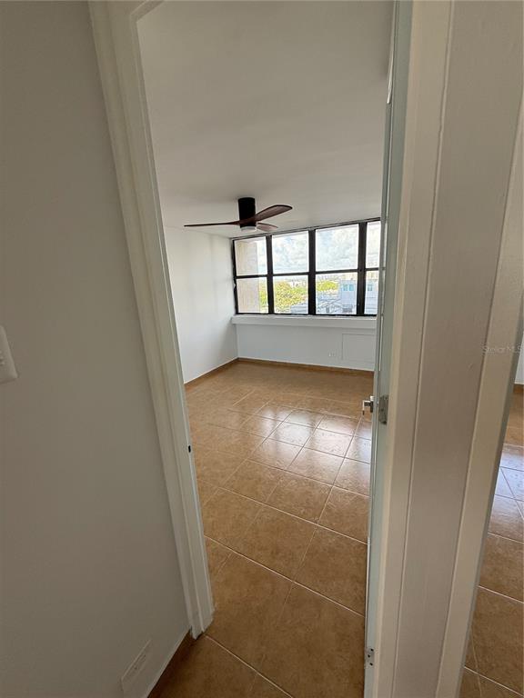 A room with tile flooring, a ceiling fan, and large windows overlooking a city view — 364 CALLE SAN JORGE UNIT 3G, SAN JUAN, PR