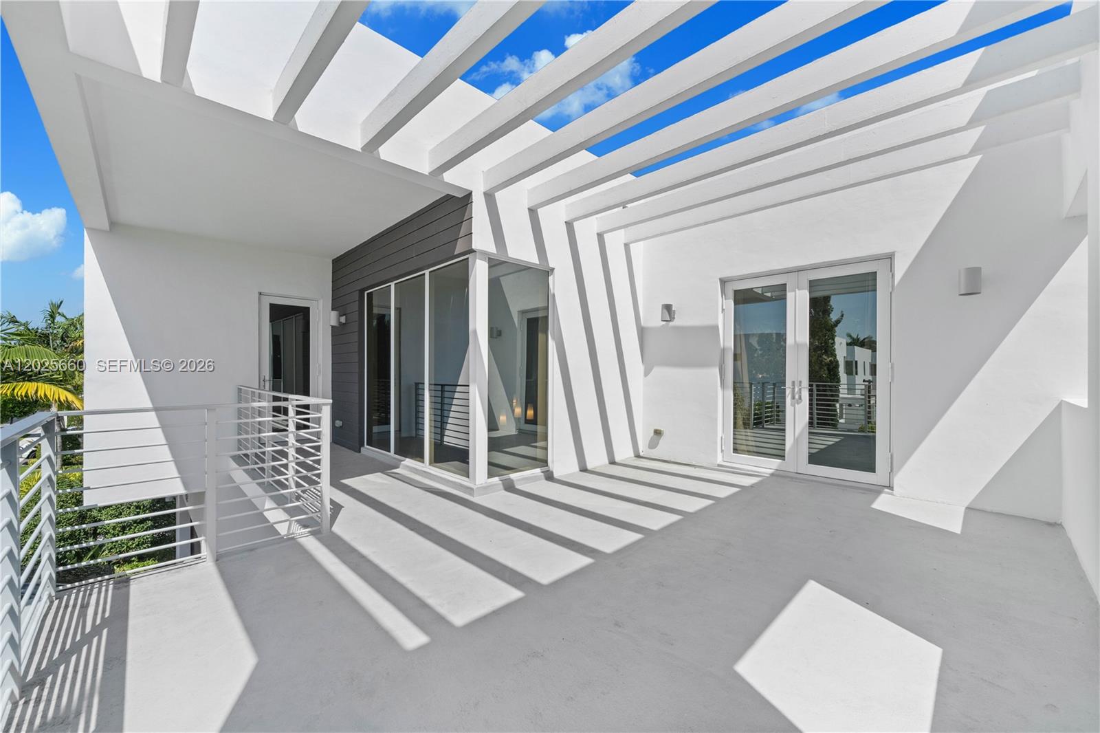 A modern outdoor terrace features a white pergola, glass doors, and a metal railing — 9915 NW 75th St, Doral FL 33178, DORAL, FL