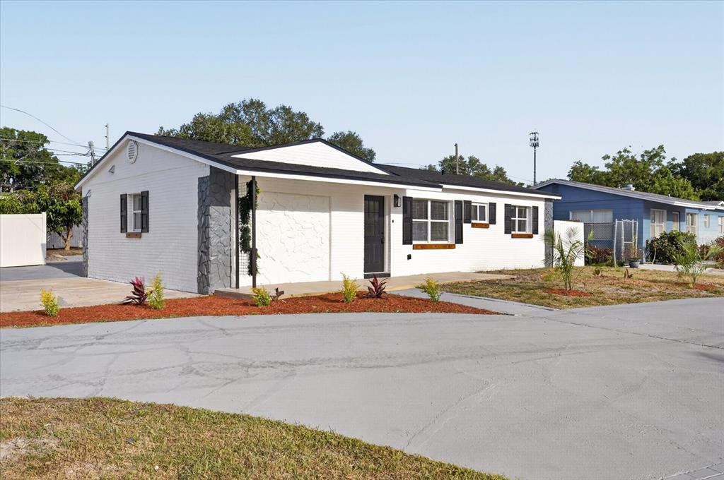A white, single-story house with black shutters and a gray stone accent wall — 13589 120TH STREET, LARGO, FL