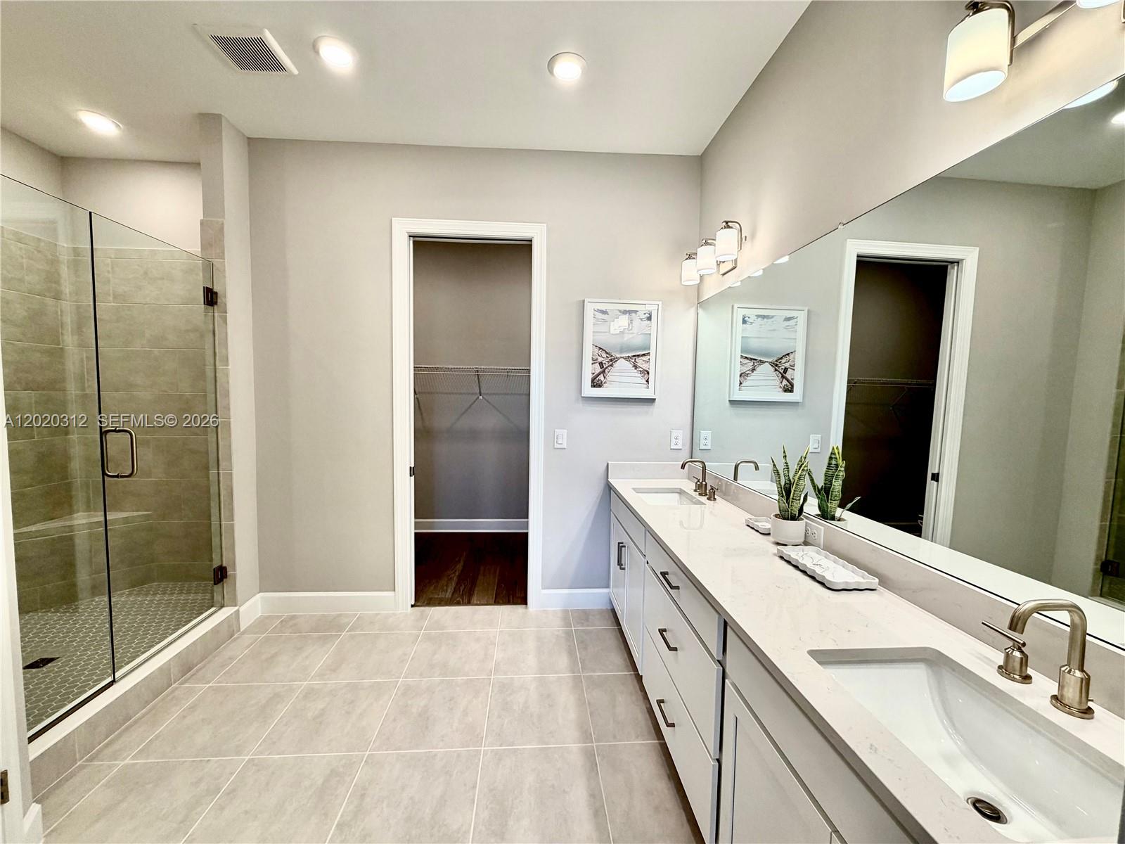 A modern bathroom features a double vanity, a glass-enclosed shower, and a walk-in closet — 15323 Lucerna # 204, Naples FL 34114, NAPLES, FL