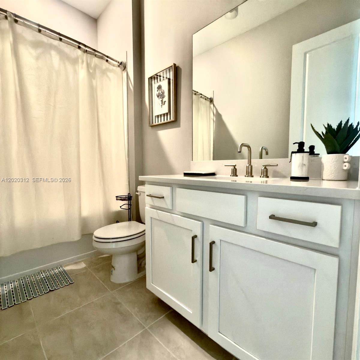 A bathroom features a white vanity with a quartz countertop, a toilet, and a shower — 15323 Lucerna # 204, Naples FL 34114, NAPLES, FL