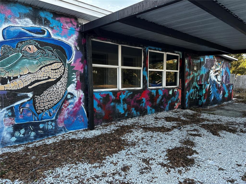 The exterior of a building features a large alligator mural and a covered gravel area — 5145 GULFPORT BOULEVARD S, GULFPORT, FL