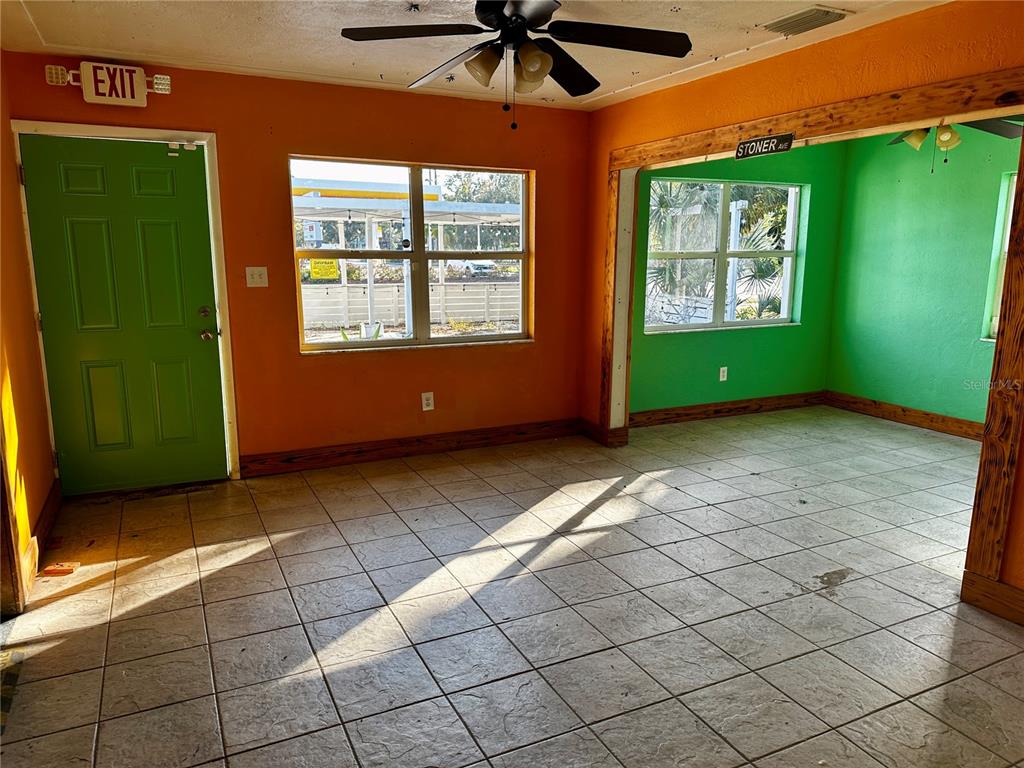 An interior room features orange and green walls, tiled floors, and a green exit door — 5145 GULFPORT BOULEVARD S, GULFPORT, FL