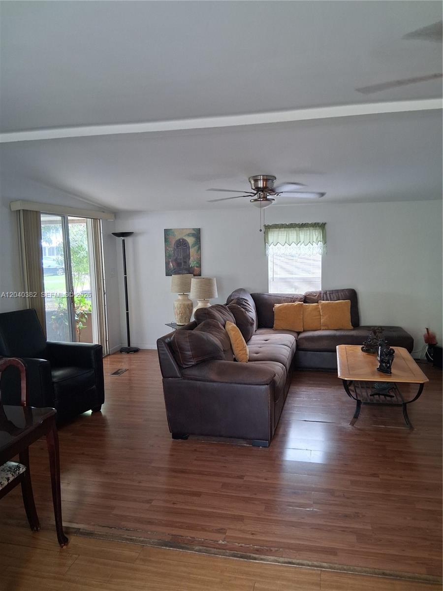 A living room features a brown sectional sofa, a coffee table, and wood-look flooring — 5030 SW 30th Ave, Dania Beach FL 33312, DANIA BEACH, FL