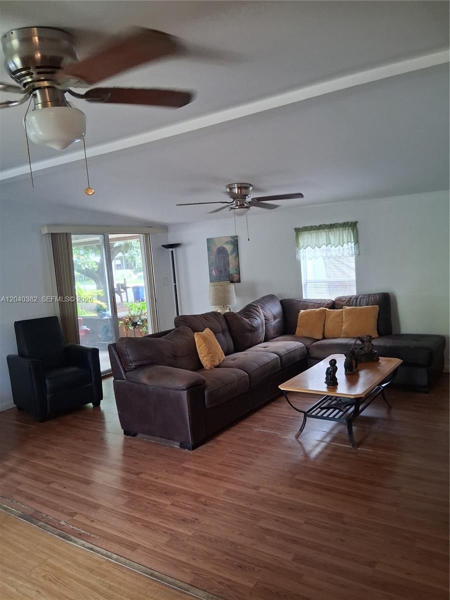 A living room features a brown sectional sofa, a black armchair, and wood-look flooring — 5030 SW 30th Ave, Dania Beach FL 33312, DANIA BEACH, FL