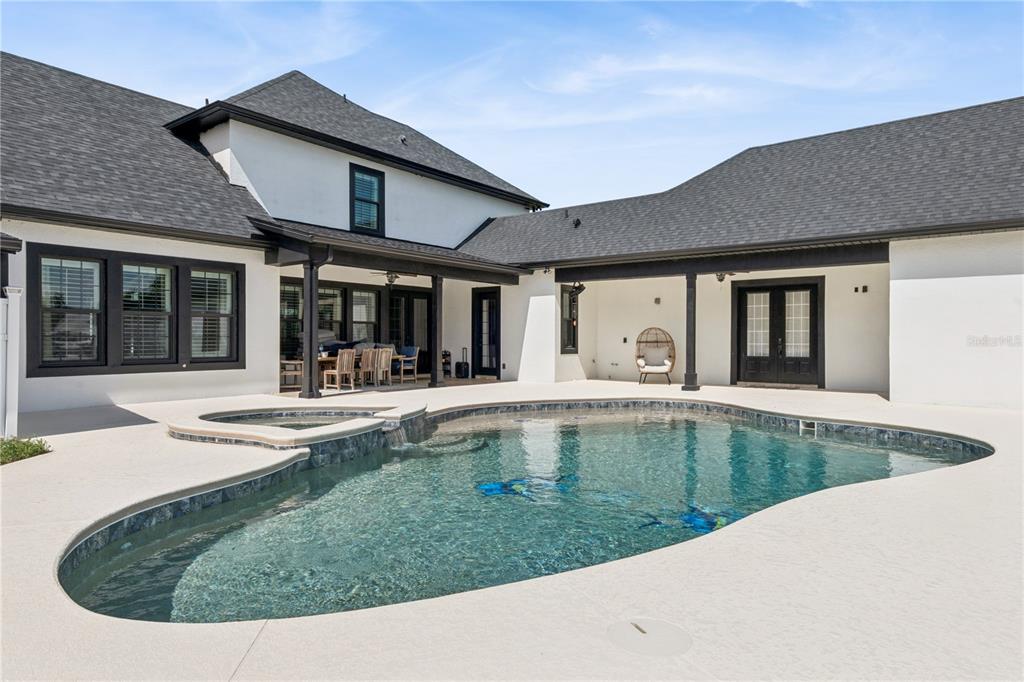 A white house with black trim features a swimming pool and a covered patio — 345 CYPRESS ISLES ROAD, OSTEEN, FL
