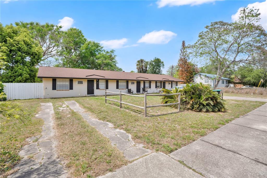 A single-story multi-unit building with a brown roof, beige siding, and a front yard — 722 TUCKER AVENUE, ORLANDO, FL