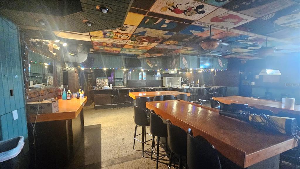 A bar interior features wooden counters, black stools, and a ceiling decorated with painted tiles — 508 CYPRESS GARDENS BOULEVARD, WINTER HAVEN, FL