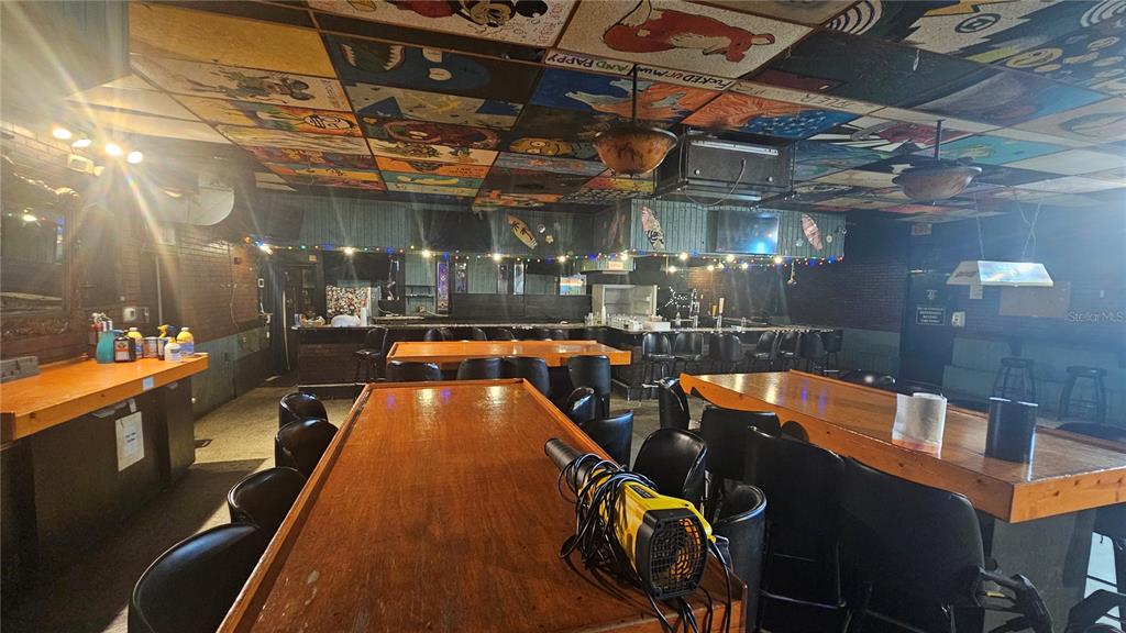 A bar interior features wooden tables, black chairs, and a ceiling decorated with painted tiles — 508 CYPRESS GARDENS BOULEVARD, WINTER HAVEN, FL