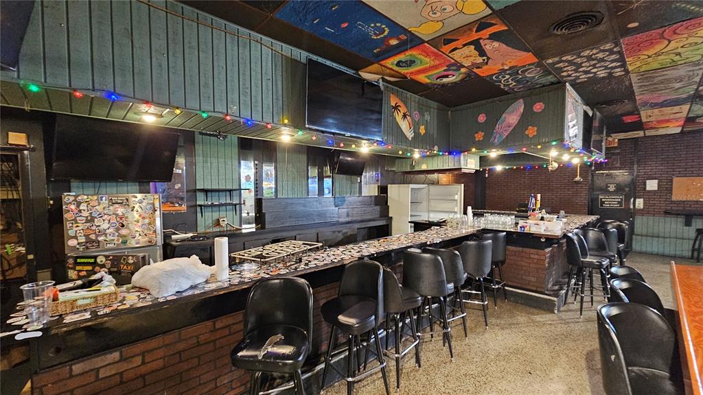 A bar interior features a long counter with stools, brick walls, and a painted ceiling — 508 CYPRESS GARDENS BOULEVARD, WINTER HAVEN, FL