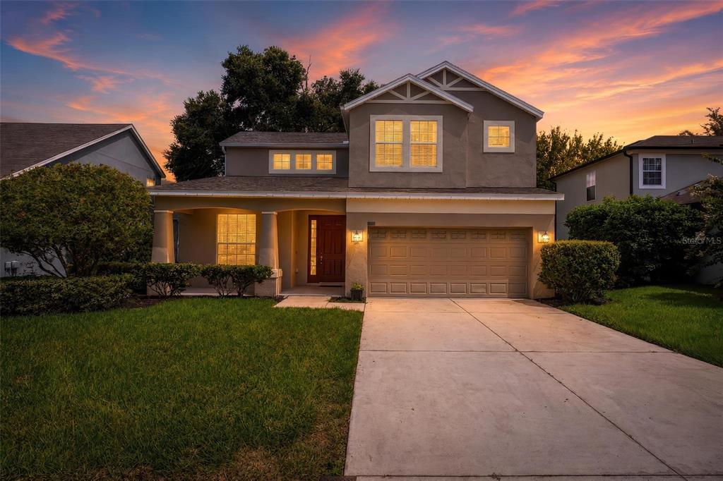 A two-story suburban house with a concrete driveway, a front porch, and a garage — 3626 OAK BROOK LANE, EUSTIS, FL
