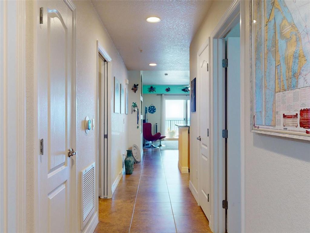 A hallway with tile flooring leads toward a living area with a view of the ocean — 5300 S ATLANTIC AVENUE UNIT 505, NEW SMYRNA BEACH, FL