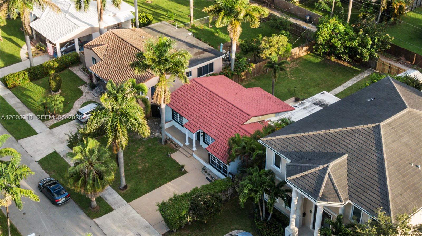 An aerial view shows a house with a red tile roof and palm trees — 1422 Wiley St, Hollywood FL 33020, HOLLYWOOD, FL